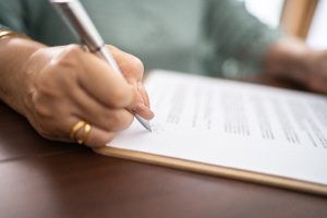 Close-up of document being signed by woman