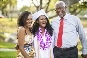 A beautiful young black teenage girl and her family celebrate graduation