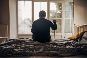 A lonely man is sitting on the bed